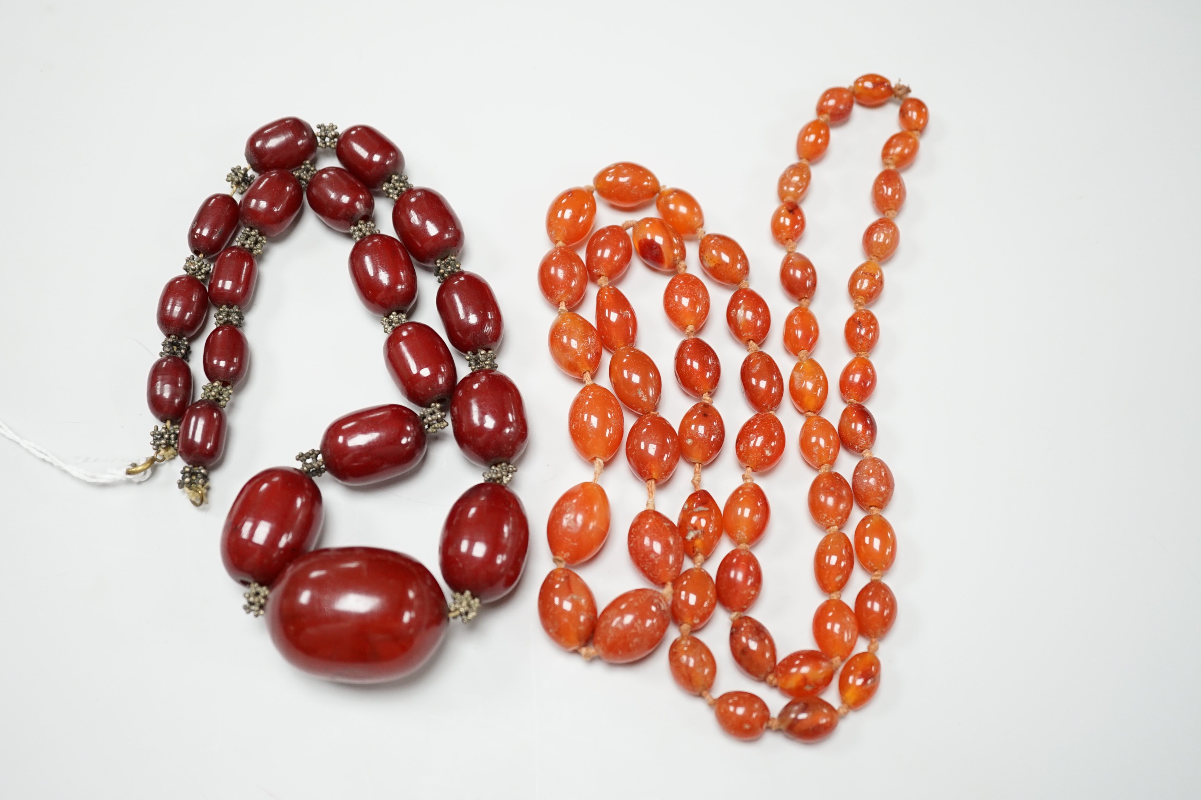 A simulated graduated red amber bead necklace, 52cm and an orange agate bead necklace, 92cm